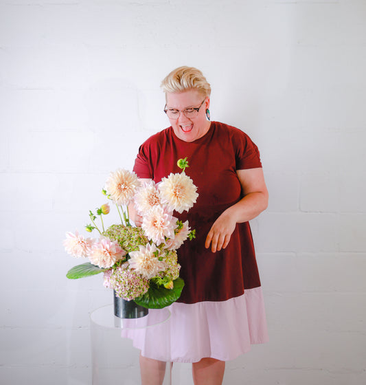 A large urn filled with stunning red roses and pink chrysanthemums