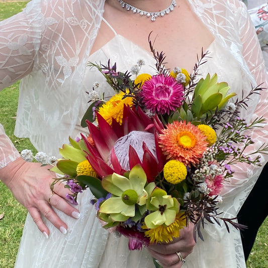 Bright, colourful native wedding bouquet held by a bride