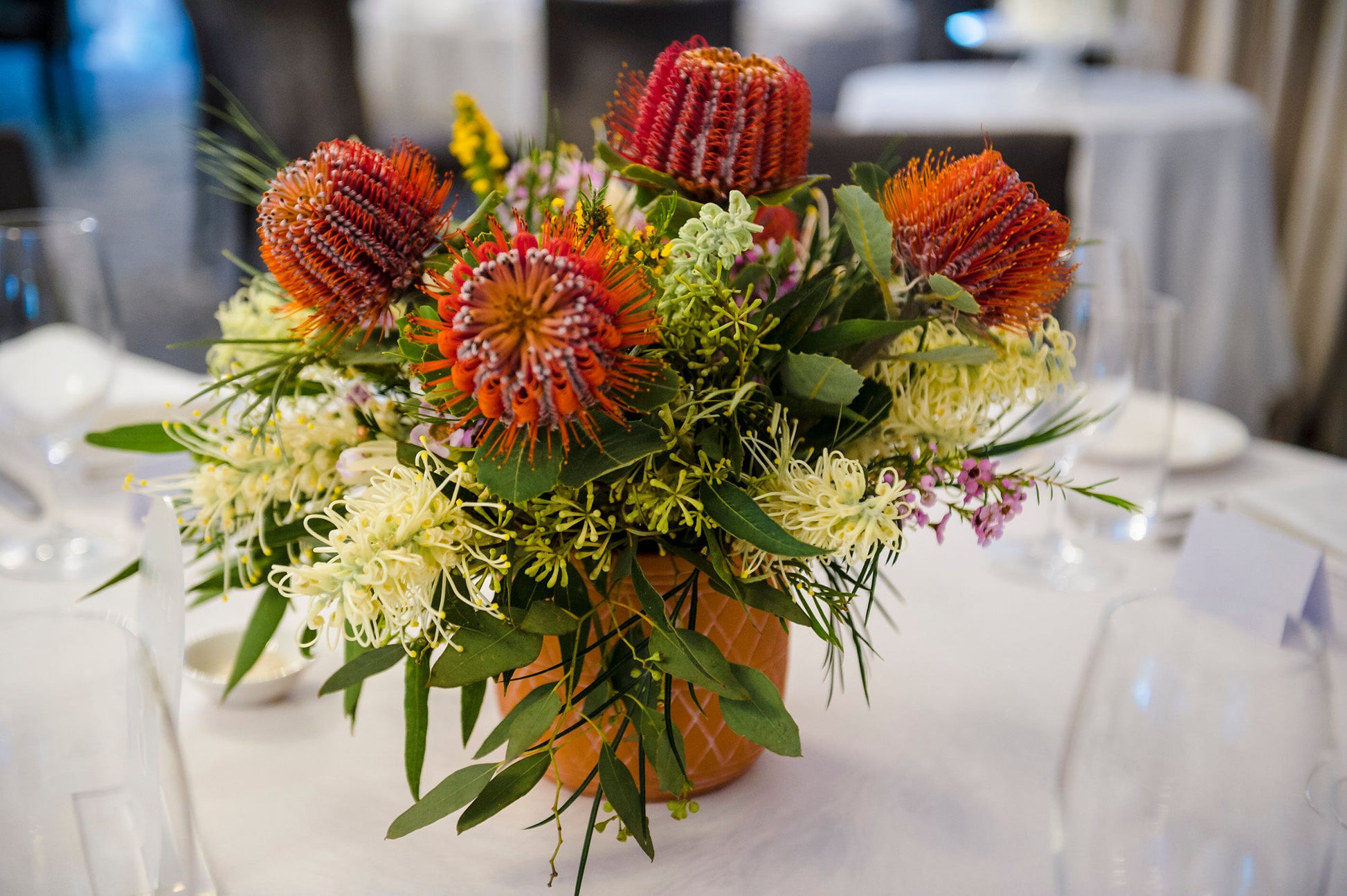 A native Australian flower table arrangement with red bottlebrush and yellow wattle made by Bold Botanicals