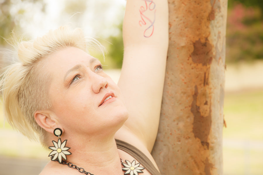 Doodad and Fandango designed earrings on a model depicting a Flannel Flower. Shot in the bush, against a gum tree.