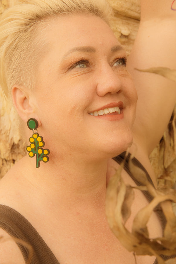 Doodad and Fandango designed earrings depicting yellow wattle on a model.