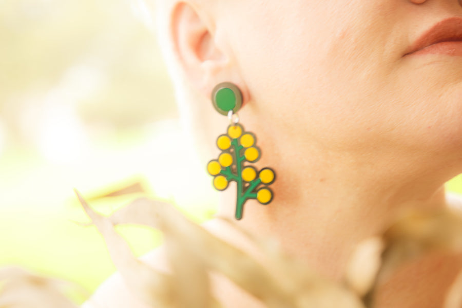 Doodad and Fandango designed earrings on a model closeup, depicting bright yellow Wattle